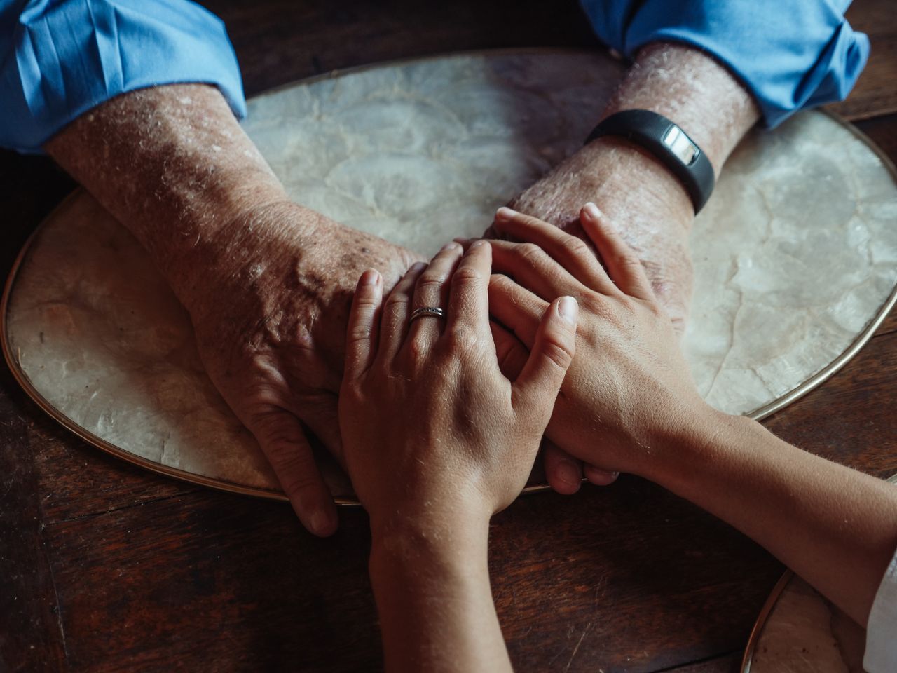 Services Close-up of elderly and young hands joined, symbolizing compassion and support.