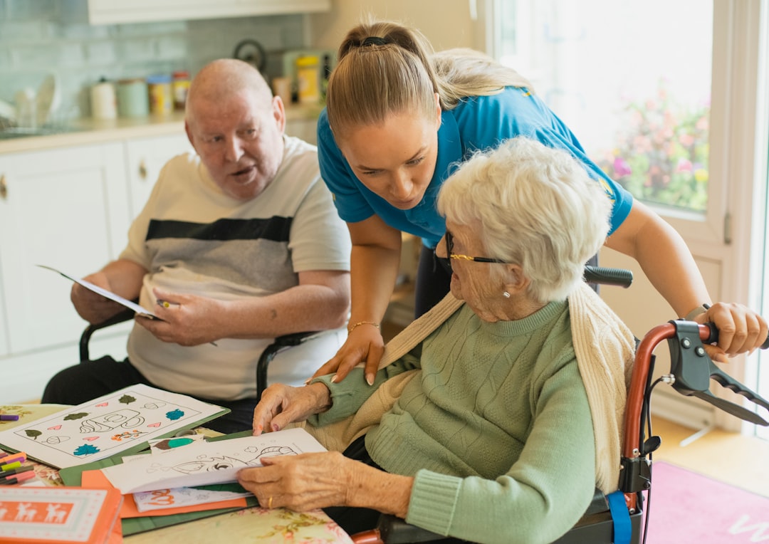 About caregiver-assisting-elderly-couple-with-coloring-bsxk1lop8t0